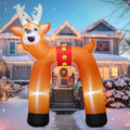 Wide inflatable reindeer archway over a driveway at dusk