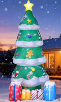 Inflatable green Christmas tree with ornaments and a star on a lawn at dusk
